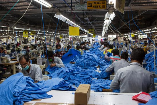 P9H649 A view down the length of a production line in a garment factory in Indore, India.